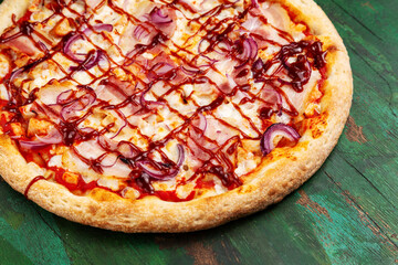 Pizza with bacon, onions, cheese and BBQ sauce. Close-up.