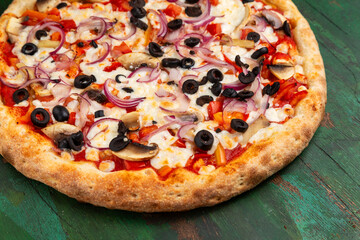 Pizza with cheese, mushrooms, tomatoes, peppers, onions and olives. Close-up.