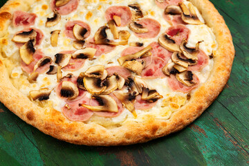 Pizza with ham, cheese, mushrooms. Close-up.