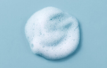 Foam smudge on blue background. Liquid soap bubbles, Froth bubbles backdrop. Drop. Cosmetics soap...