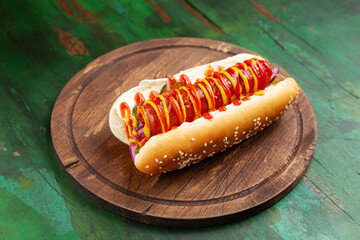 Hot dog, bun with sausage and ketchup and mustard on a wooden board. Fast food.
