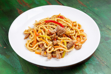 Wok noodles, noodles with pork, carrots and peppers.