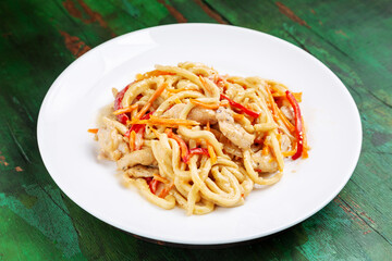 Wok noodles, noodles with chicken, carrots and peppers in a creamy sauce.