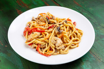 Wok noodles, noodles with chicken, mushrooms, carrots and peppers.
