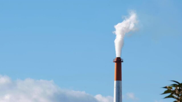 The chimney of a power plant with cloud sky.