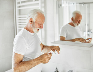 man tooth bathroom toothbrush hygiene senior morning routine brushing toothpaste care dental elderly home retirement mouth mirror health cleaning - Powered by Adobe