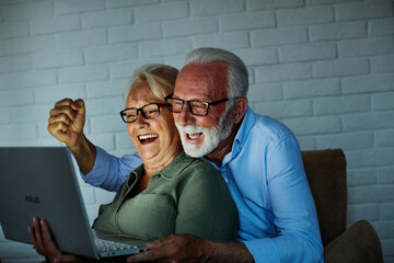 television watching couple laptop night computer elderly sport soccer senior football fan home...