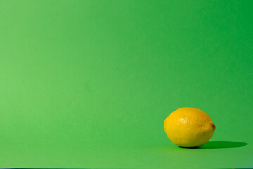 Single lemon citrus fruit against a seamless green background