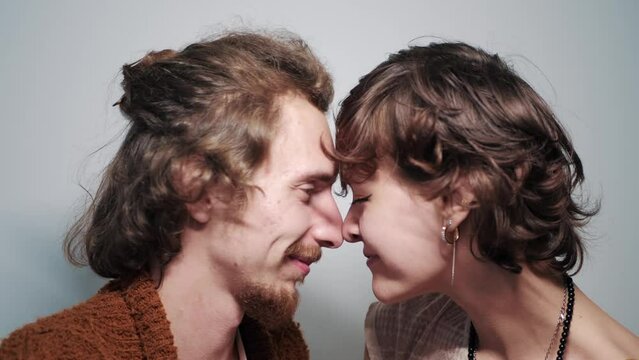 Young couple of lovers rub their noses against each other and smile, romantic evening.