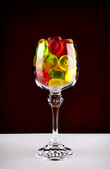 Glass goblet full of beautiful multi-colored candies. Multi-colored candies in a glass goblet.