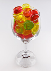 Glass goblet full of beautiful multi-colored candies. Multi-colored candies in a glass goblet.