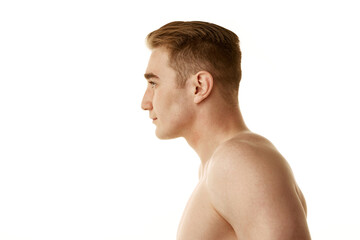 Naklejka premium Shirtless young guy with redhead, clear, spotless skin standing isolated over white background. Concept of male beauty, skin care, cosmetology and cosmetics, health