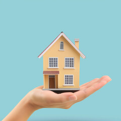 Hand presenting a model home symbolizing real estate.	