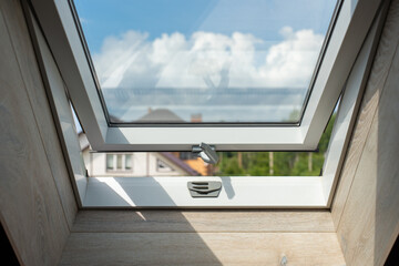 open attic window, view of the sky and houses. High quality photo