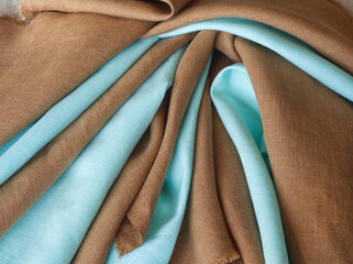Brown and blue draped linen fabric. Woven  texture background. Various colors textile drapery for...