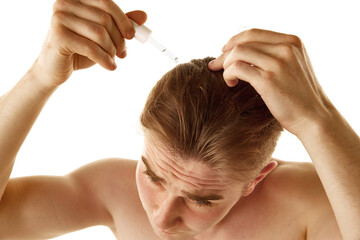 Fototapeta premium Young shirtless man taking care after health, applying head oil, serum isolated over white background. Concept of male beauty, skin care, cosmetology and cosmetics, health