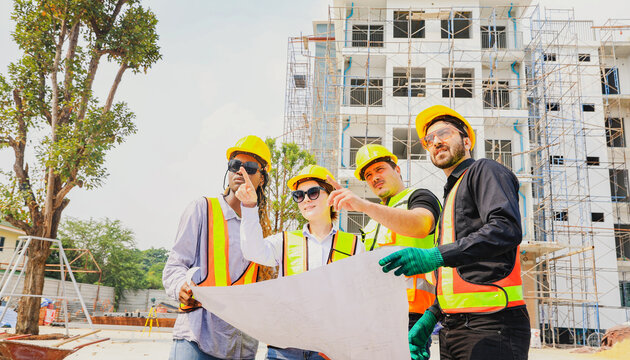 Team architects multi ethnic workers men and women meeting brainstorming construction of condominium buildings civil engineers examining blueprints giving advice planning projects housing real estate. - Powered by Adobe