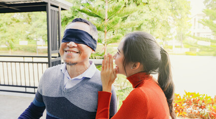 Obraz premium Grateful daughter beautiful eldest daughter covered her eyes with black cloth surprise your retired old man and whisper sweet words into his ear by buying him new house as a gift.