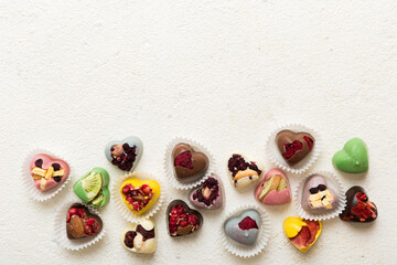 chocolate sweets in the form of a heart with fruits and nuts on a colored background. top view with space for text, holiday concept