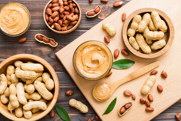 Bowl of peanut butter and peanuts on table background. top view with copy space. Creamy peanut pasta in small bowl