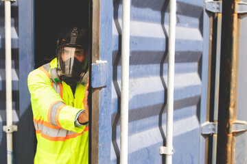 Male rescue worker wearing uniform PPE and wear mask to prevent accidents from dangerous stench toxins inside the container that are illegally transported into the country. Open the door carefully. - obrazy, fototapety, plakaty