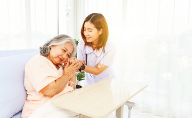 Female doctor holds the hand elderly female patient showing positive expressions encouragement good wishes each other heal sick person normal healthy spread happiness together in the hospital.