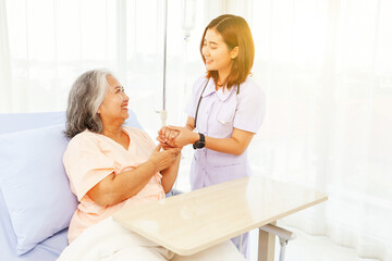 Obraz premium Female doctor holds the hand elderly female patient showing positive expressions encouragement good wishes each other heal sick person normal healthy spread happiness together in the hospital.