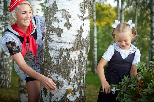 Young and adult schoolgirl on September 1, mother and daughter having fun together. Generations of schoolchildren of USSR and Russia. Female pioneer in red tie and October girl in modern uniform