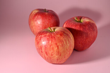 three red apples on a pink background 5