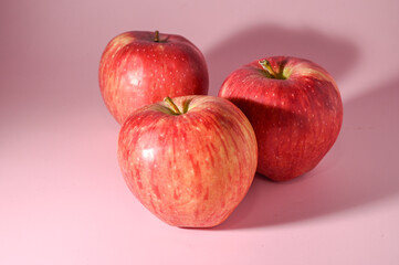 three red apples on a pink background 6