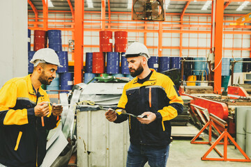 Two male workers team wearing hardhat stand sort cut metal sheets into trash bins for recycling and...