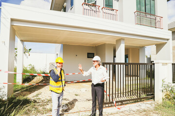 Senior architect talks with workers and safety officers housing construction project taped prevent entry due to dangers during construction warning careful prevent danger in order to reduce accidents.