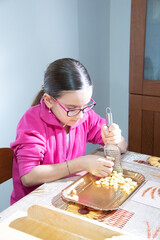 Bambina di nove anni mentre prepara un piatto tipico natalizio.