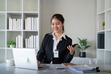 Charming Asian business woman sitting working on laptop in office