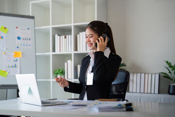 Fototapeta premium Happy confident businesswoman talking on the phone. Smiling female business person talking work using talking on the phone at office sitting at desk