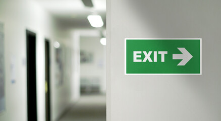 Emergency exit sign on the right with blurred corridor background. Space on the left, for copy...