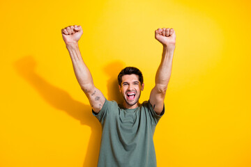 Photo of ecstatic man with bristle dressed khaki t-shirt raising hands up scream yes win betting...