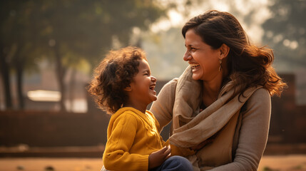 A photographic composition that freezes a heartwarming moment of a happy Indian mother having fun with her daughter outdoors.  - Powered by Adobe