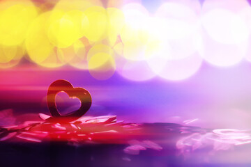 Abstract colored background. Red toy in the shape of a heart on a glitter and bokeh background.