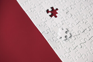 Clean puzzle elements on the red background. Empty puzzle piece on the table. Teamwork concept.