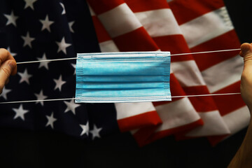 Fototapeta na wymiar American health care system. USA flag background. Medical mask and restrictions.