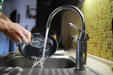 Man washing dish in sink at restaurant.People are washing the dishes too Cleaning solution