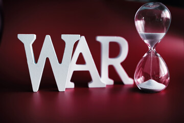WAR, word written in wooden alphabet letters on red background. The concept of a terrible war...