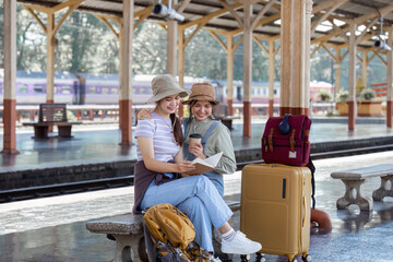 Woman traveler with backpack looking at planning vacation on holiday relaxation at the train station