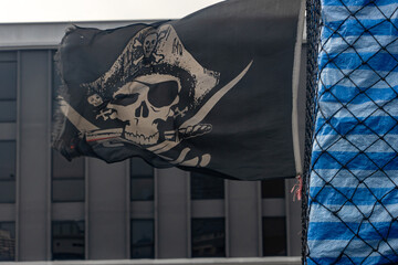 A pirate flag flies behind a moving pickup truck with cargo