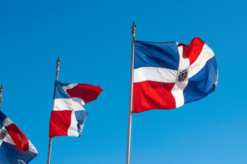 Dominican Republic flags waving against  blue sky