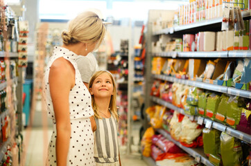 Young woman with daughter in supermarket