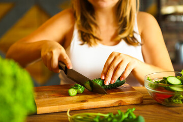 Young woman making vegetable salad