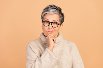 Portrait of minded aged person hand touch chin brainstorming ponder isolated on beige color background