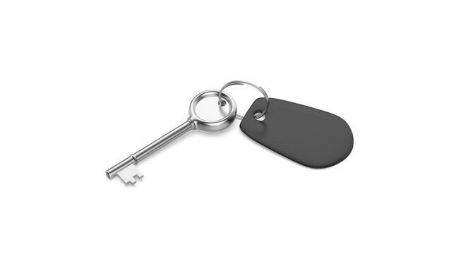 Silver old-fashioned key and blank black keyring on white background
